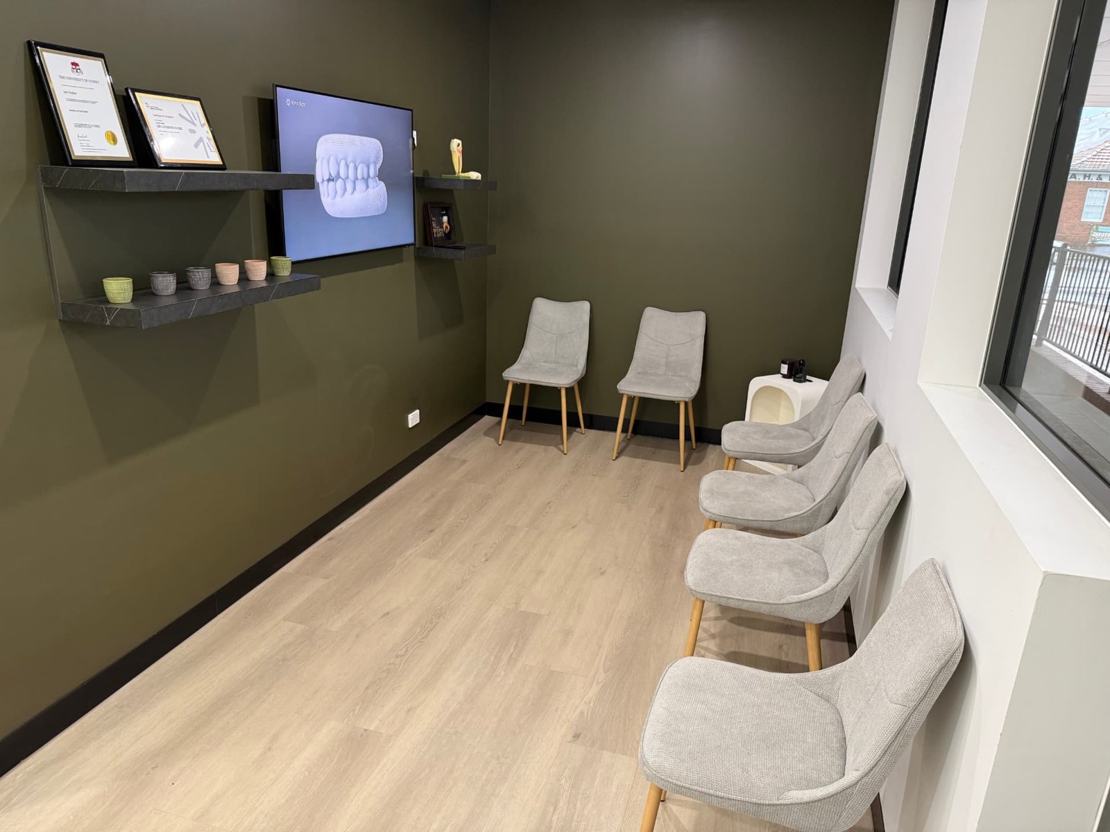 Our waiting area with comfortable seating and an olive feature wall